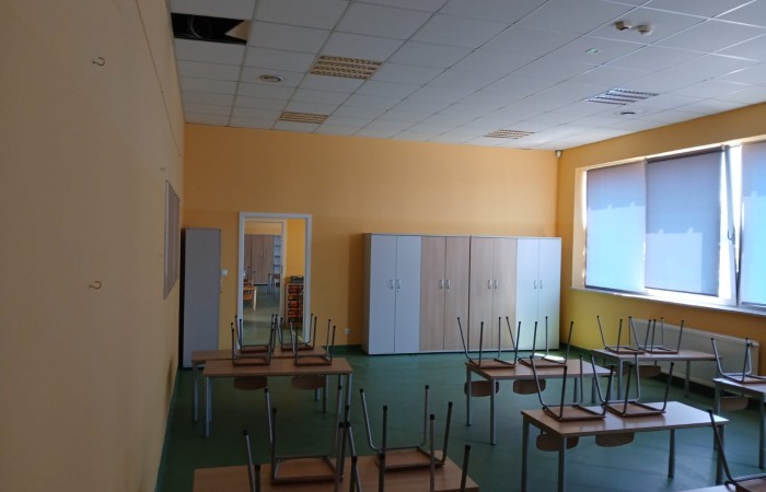 sala lekcyjna z podniesionymi krzesłami do góry