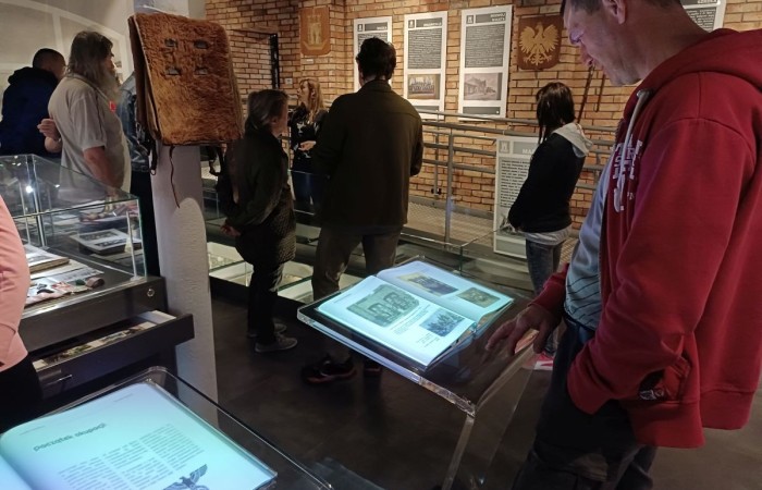 grupa osob podziwia gabloty z wystawiami