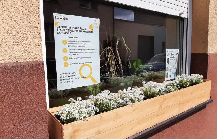 doniczki na oknie przed centrum integracji społecznej