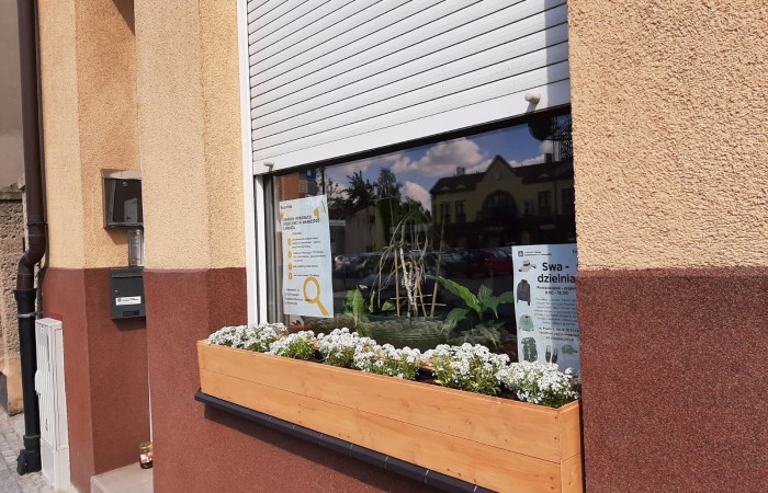 doniczki na oknie przed centrum integracji społecznej