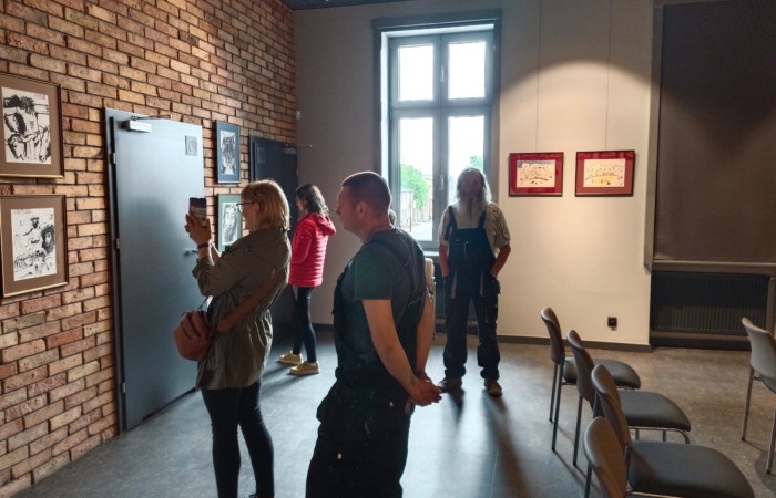 uczestnicy podziwiają obrazy na wystawie