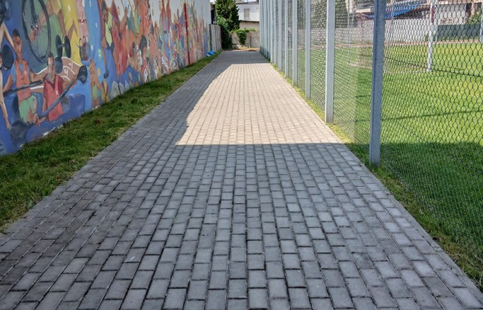 wyczyszczona kostka brukowa przy boisku piłkarskim